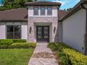 Elegant entryway with double doors, stone accents, and a paved walkway at 32117 Red Tail Blvd, Sorrento, FL 32776