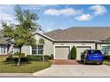 Attractive home featuring a two-car garage, brick driveway, mature trees, and neatly trimmed landscaping at 3525 Belland Cir # A, Clermont, FL 34711