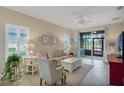 Bright living room featuring tile floors, a ceiling fan, neutral paint, and sliding glass doors to the patio at 3525 Belland Cir # A, Clermont, FL 34711
