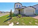 Charming two-story home with an attached two-car garage, complemented by green lawn at 4034 Copperleaf Ln, Poinciana, FL 34759