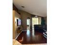 Living room with hardwood floors, a large sectional sofa, and access to a Florida room at 491 Goldenmoss Loop, Ocoee, FL 34761