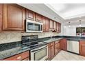 This kitchen features dark wood cabinets, black granite countertops, and stainless steel appliances at 530 E Central Blvd # 102, Orlando, FL 32801