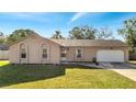 Charming single-story home with a well-manicured lawn, arched windows, a two-car garage and inviting curb appeal at 731 Mimosa Ct, Winter Springs, FL 32708