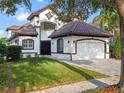 Beautiful two-story home with a tile roof and a two-car garage, set in a lush green lawn at 8519 Saint Marino Blvd, Orlando, FL 32836