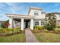 Inviting two-story home boasts a tiled roof, lush landscaping, and a welcoming covered front porch at 10231 Beechwood Ln, Orlando, FL 32832