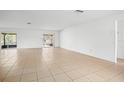 Bright and airy living room featuring tile flooring and sliding glass doors leading to an enclosed patio at 10305 Licorice Way, Orlando, FL 32821