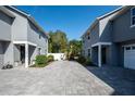 Gray townhouses showing driveway with landscaped plantings, blue sky and white fence at 1217 E Muriel St, Orlando, FL 32806
