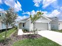 Charming single-story home with a well-manicured lawn, a two-car garage, and a walkway to the front door at 2206 Lovely Ln, Davenport, FL 33897