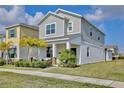 Two-story house with gray siding, palm trees, and a porch at 2429 Volunteer Ave, Kissimmee, FL 34744