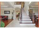 Elegant foyer featuring hardwood and tile flooring with a staircase and views to the living room at 2438 River Rise Ct, Orlando, FL 32828