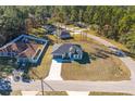 Aerial view of a single-story home with a spacious yard surrounded by mature trees at 325 Marion Oaks Golf Way, Ocala, FL 34473