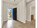 Bright foyer with tile flooring, a view of the front yard and a powder room to the side at 3773 Moon Dancer Pl, St Cloud, FL 34772