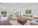 Open-concept living space with modern furniture, stainless steel appliances and wood-look flooring throughout the home at 42 Fisher Way Trak, Ocklawaha, FL 32179