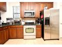 Stainless steel appliances and dark wood cabinets in this kitchen at 4401 Messina Dr, Lake Mary, FL 32746