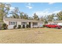 Charming single-story home featuring a well-manicured lawn, and a red truck parked in the driveway at 5326 Metro Dr, Orlando, FL 32818