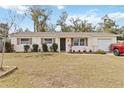 Charming single-story home with manicured lawn, freshly painted exterior, and mature trees at 5326 Metro Dr, Orlando, FL 32818