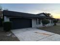 Newly painted home with a black garage door and landscaping at 6432 Delta Leah Dr, Orlando, FL 32818