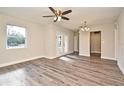 Open-concept living room with wood-look floors, neutral walls, and access to other rooms at 878 Rockhill St, Deltona, FL 32725