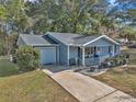 Aerial view of a charming ranch home with a driveway and neat landscaping at 10897 Sw 80Th Ct, Ocala, FL 34481