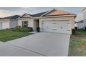 Well-maintained single-story home with an attached two-car garage and neat landscaping at 1207 Tank Trl, Haines City, FL 33844