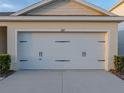 Close-up of the two-car garage door with decorative hardware and the house number above at 1207 Tank Trl, Haines City, FL 33844