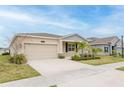 Attractive one-story home with a spacious driveway, well-maintained lawn, and verdant landscaping at 16462 Glassy Loch Loop, Clermont, FL 34714