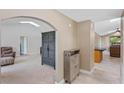 Open concept entryway with neutral colors and arched doorways leading to a cozy living area and kitchen at 1971 Urbana Ave, Deltona, FL 32725