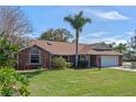 Attractive brick home featuring lush landscaping, a well-manicured lawn and a spacious two-car garage at 1971 Urbana Ave, Deltona, FL 32725