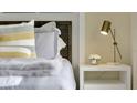 Main bedroom with soft grey bedding, a white nightstand, and a brass lamp at 2148 Pigeon Plum Dr, Haines City, FL 33844