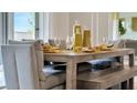 Modern dining area with a light wooden table and grey cushioned bench seating at 2148 Pigeon Plum Dr, Haines City, FL 33844