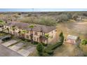 Aerial view of a neighborhood, with manicured lawns, towering trees, and community seating with a sun shade at 2153 Calabria Ave, Davenport, FL 33897