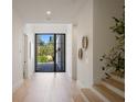 Bright foyer with hardwood floors and a modern glass door leading to the exterior at 2412 Chantilly Ave, Winter Park, FL 32789