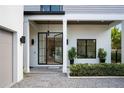 Elegant entryway featuring a modern glass door, stone path, and stylish landscaping at 2412 Chantilly Ave, Winter Park, FL 32789