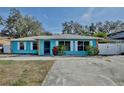 Lovely turquoise home featuring a metal roof, stone accents, and a well-maintained front yard at 27622 Lois Dr, Tavares, FL 32778