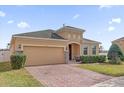 Charming single-story home with brick driveway, two-car garage, arched entryway and manicured landscaping at 3337 Reedy Glen Dr, Kissimmee, FL 34758