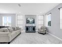 Bright living room featuring white marbled tile floors, modern furnishings, decorative wall accents, and natural light at 3337 Reedy Glen Dr, Kissimmee, FL 34758