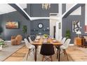 Modern dining room with wooden table, black accent wall, and a stylish chandelier at 421 Boxwood Dr, Davenport, FL 33837