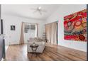 Bright living room features wood-look floors, a ceiling fan, and a vibrant abstract painting at 421 Boxwood Dr, Davenport, FL 33837