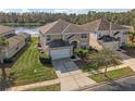 Two-story house with tan exterior, white garage door, and a lake view at 4700 Golden Beach Ct, Kissimmee, FL 34746