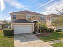 Two-story house with tan exterior, white garage door, and palm trees at 4700 Golden Beach Ct, Kissimmee, FL 34746