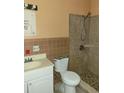 Bathroom with shower, toilet, and brown tile at 477 C St # 4, Casselberry, FL 32707