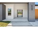 Close-up of the modern home's entrance, showcasing a stylish door and minimalist landscaping at 5544 Sw 136Th Ave, Ocala, FL 34481