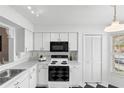 Bright kitchen features white cabinetry, contrasting black appliances, and checkerboard flooring at 564 Shadow Glenn Pl, Winter Springs, FL 32708
