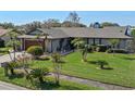 Single-story home showcasing a lush, green lawn and a variety of mature tropical plants and landscaping at 616 Mellowood Ave, Orlando, FL 32825