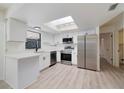 Updated kitchen featuring white cabinets, stainless steel appliances, and skylight at 8546 Amber Oak Dr, Orlando, FL 32817