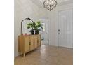 Foyer with tile flooring, a decorative cabinet with mirror, and modern light fixture at 1942 Rankin St, Kissimmee, FL 34744