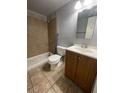 Bathroom with tiled stand-up shower, commode, and vanity with wooden cabinet at 285 Scottsdale Sq # 285, Winter Park, FL 32792