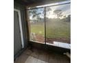 Screened patio overlooking a shared yard, with green grass, and community structures in the distance at 285 Scottsdale Sq # 285, Winter Park, FL 32792