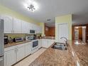 Bright kitchen with granite counters, stainless steel appliances, and white cabinetry at 5409 Caramella Dr, Orlando, FL 32829