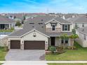 Aerial view showcases a two-story home with a three-car garage, surrounded by a landscaped yard at 739 Annabell Ridge Rd, Minneola, FL 34715